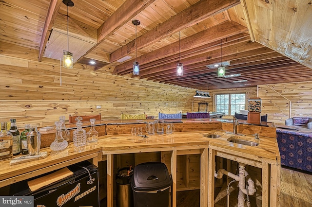 misc room featuring wooden walls, hardwood / wood-style floors, wood ceiling, and wet bar