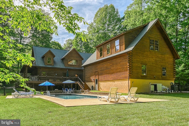 rear view of house with a fenced in pool, central AC, and a patio area