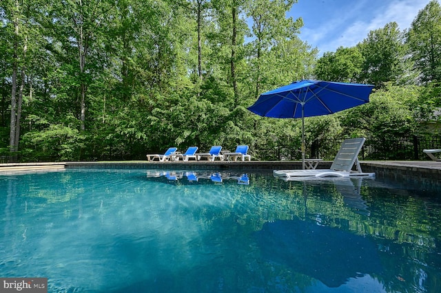 view of swimming pool featuring a water view