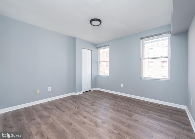 unfurnished room with hardwood / wood-style flooring