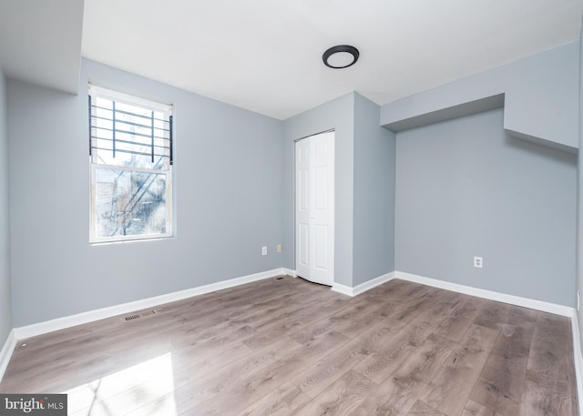 unfurnished room with wood-type flooring