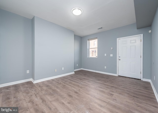 empty room with hardwood / wood-style flooring