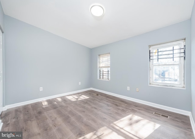 unfurnished room with wood-type flooring