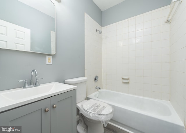 full bathroom with toilet, tiled shower / bath, and vanity with extensive cabinet space