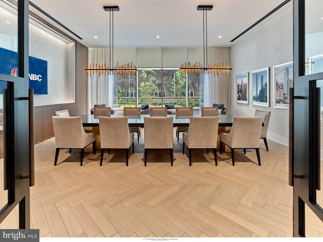 dining area with a chandelier and light parquet flooring