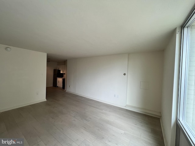 empty room with light hardwood / wood-style floors and a wealth of natural light