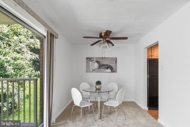 carpeted dining room with ceiling fan