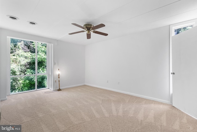 unfurnished room featuring light carpet, plenty of natural light, and ceiling fan