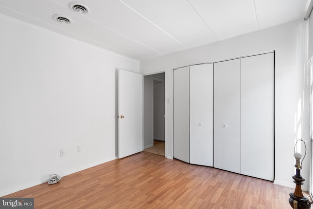 unfurnished bedroom featuring a closet and light hardwood / wood-style flooring