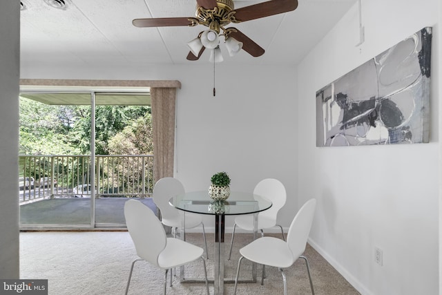 carpeted dining space featuring ceiling fan