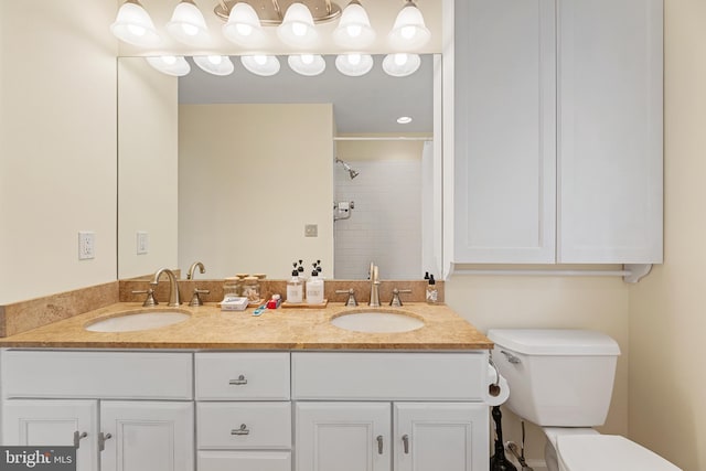 bathroom with a tile shower, vanity, and toilet