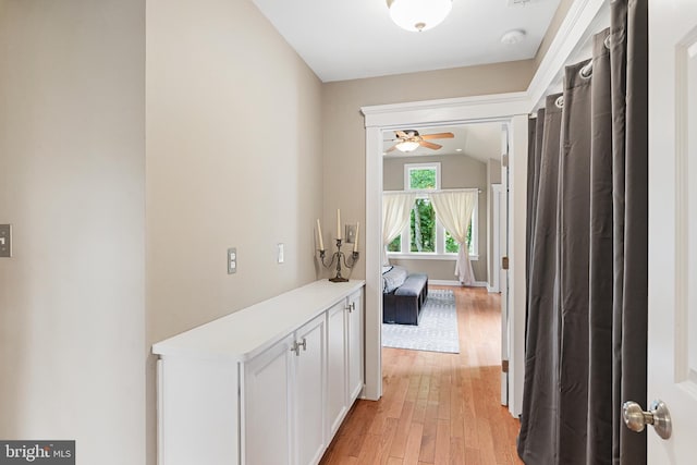 hall featuring light hardwood / wood-style floors and vaulted ceiling