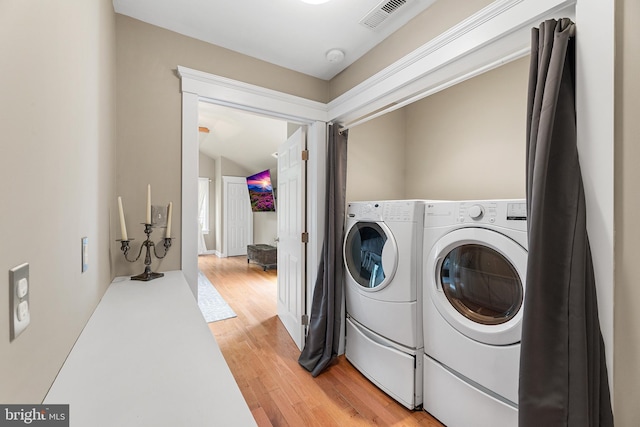 washroom featuring hardwood / wood-style flooring and washing machine and clothes dryer