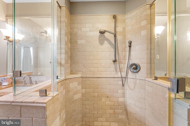 bathroom with a tile shower and sink