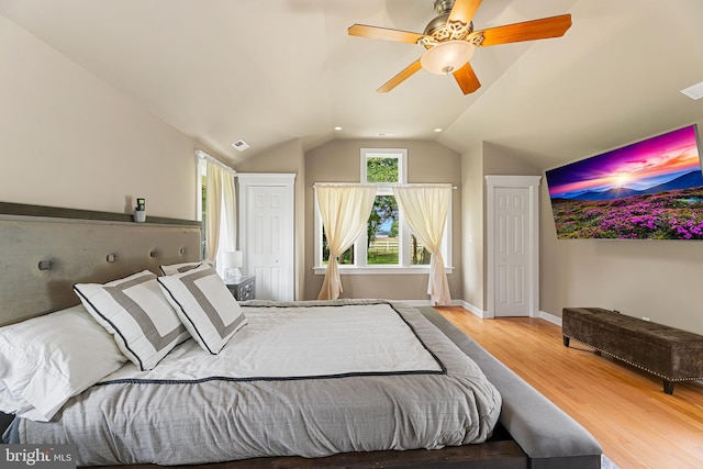 bedroom featuring ceiling fan, light wood-type flooring, and vaulted ceiling