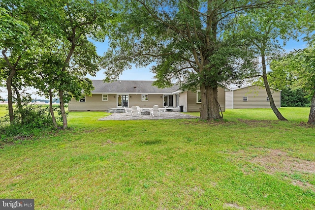 rear view of house with a lawn and a patio area