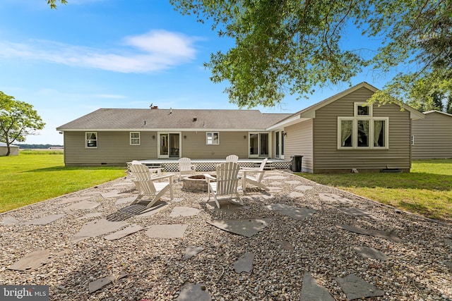 back of house with an outdoor fire pit, a patio area, and a lawn