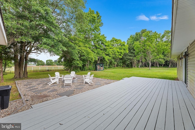 wooden deck featuring a yard and an outdoor fire pit