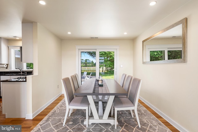 dining space with dark hardwood / wood-style flooring and sink