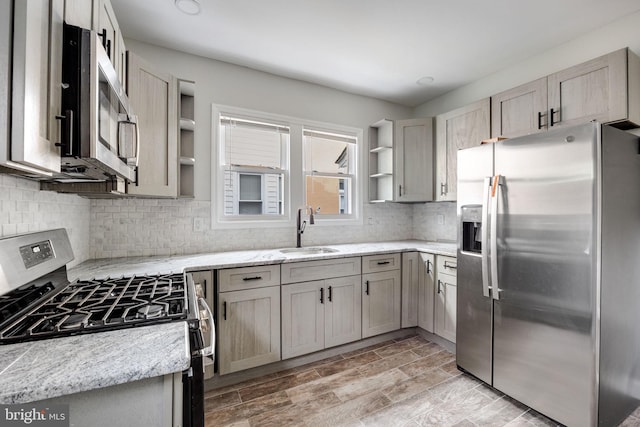 kitchen with tasteful backsplash, sink, light stone counters, and stainless steel appliances