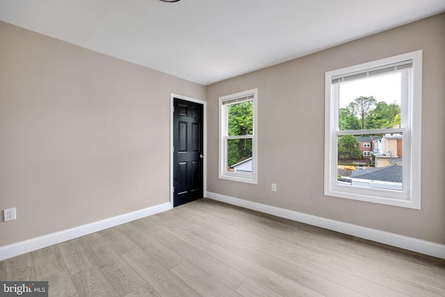 unfurnished room featuring light hardwood / wood-style floors and a healthy amount of sunlight