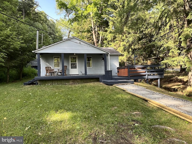 bungalow with a front yard and a wooden deck