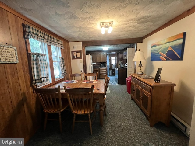 carpeted dining space featuring a textured ceiling and baseboard heating