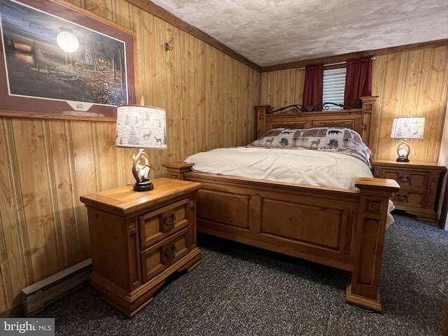 bedroom with a textured ceiling, wood walls, dark carpet, and baseboard heating