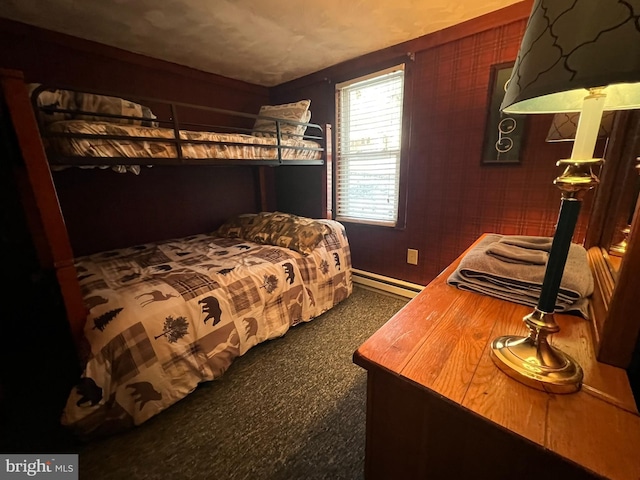 bedroom with baseboard heating and dark carpet