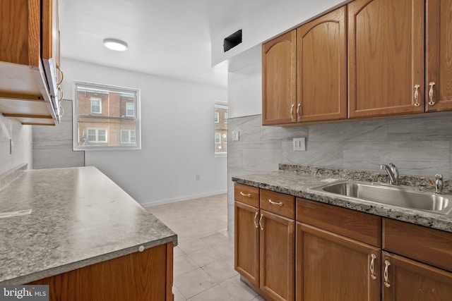 kitchen featuring sink, tasteful backsplash, and light tile flooring