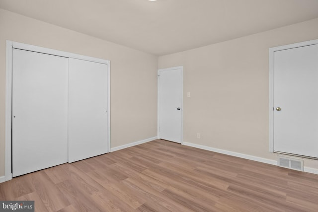 unfurnished bedroom with a closet and light hardwood / wood-style flooring