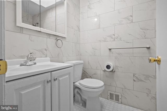 bathroom featuring tile walls, tile floors, vanity, and toilet