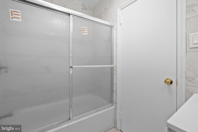 bathroom featuring bath / shower combo with glass door