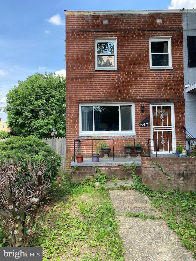 view of front of property featuring brick siding and fence