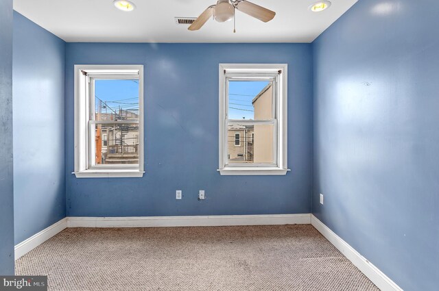 carpeted spare room with ceiling fan