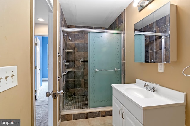 bathroom with tile patterned flooring, vanity, and walk in shower