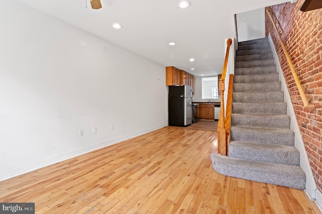 unfurnished living room with ceiling fan and light hardwood / wood-style floors