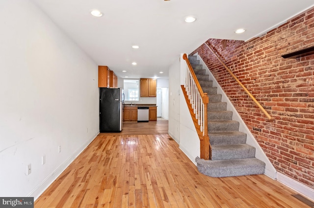 interior space featuring wood-type flooring and brick wall