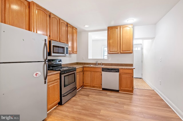 kitchen with light hardwood / wood-style floors, sink, and stainless steel appliances