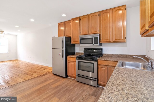 kitchen featuring sink, appliances with stainless steel finishes, and light hardwood / wood-style floors