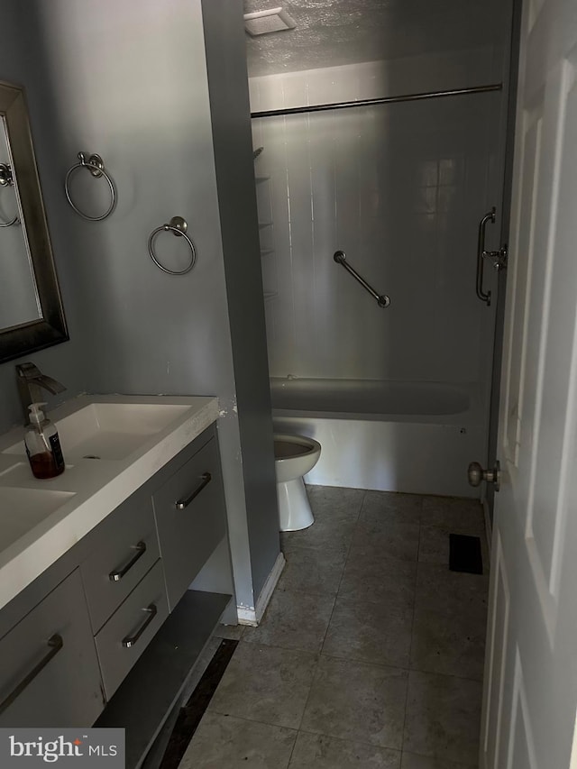 full bath featuring a textured ceiling, shower / tub combination, toilet, tile patterned flooring, and vanity