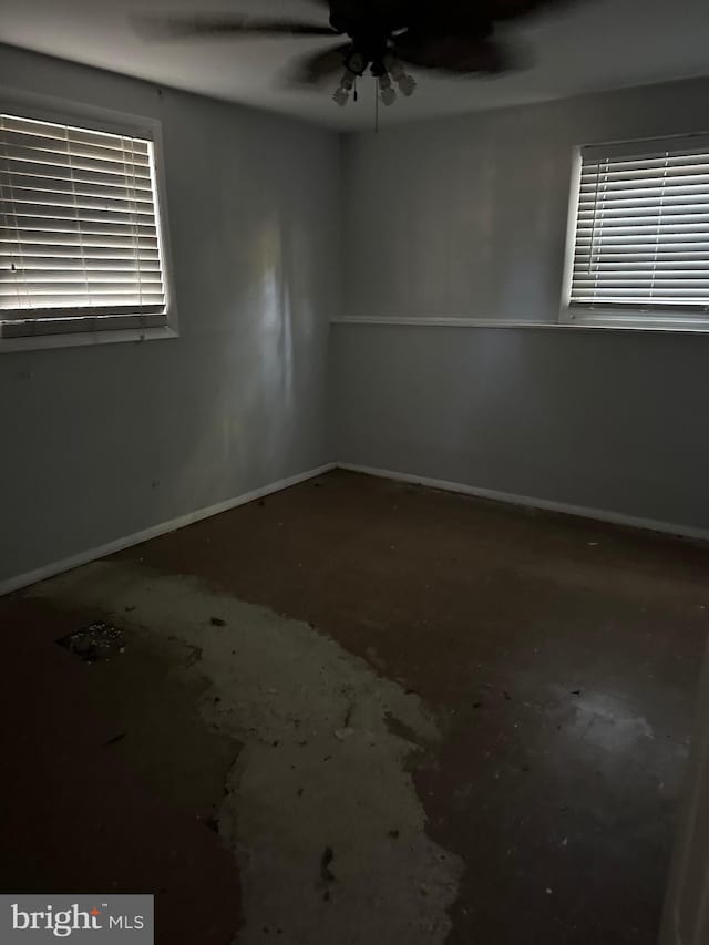 spare room featuring concrete floors and ceiling fan