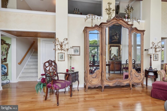 sitting room featuring a high ceiling and light hardwood / wood-style floors