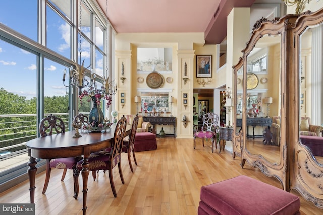 dining space featuring a high ceiling, a wealth of natural light, and light wood-type flooring