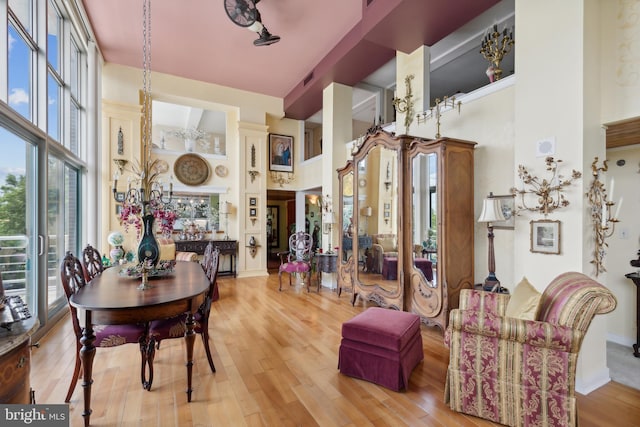 dining room featuring a towering ceiling and hardwood / wood-style flooring