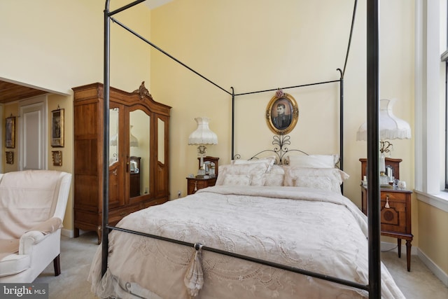 bedroom with a high ceiling and carpet flooring