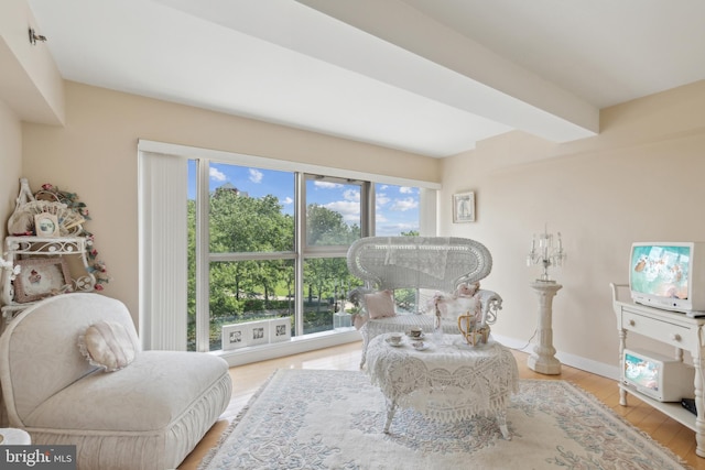 sitting room featuring beamed ceiling and light hardwood / wood-style flooring