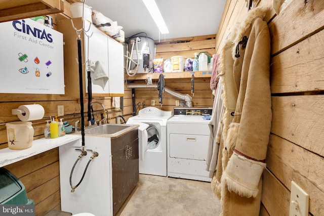 laundry room with wood walls, sink, and washing machine and clothes dryer