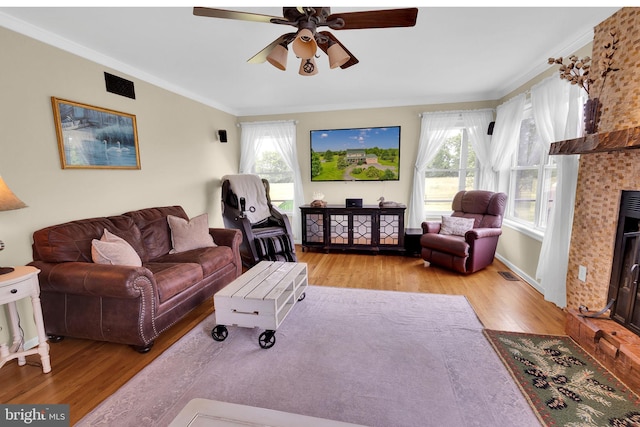 living room featuring plenty of natural light, ceiling fan, ornamental molding, and light hardwood / wood-style flooring