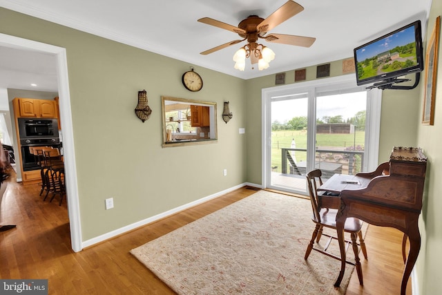 office space with light wood-type flooring, ceiling fan, and ornamental molding